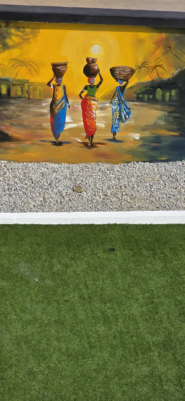 Mural of three women carrying baskets on their heads