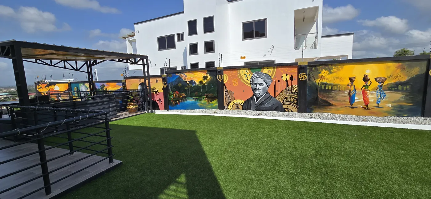Rooftop terrace with murals along the wall and the neighboring building
