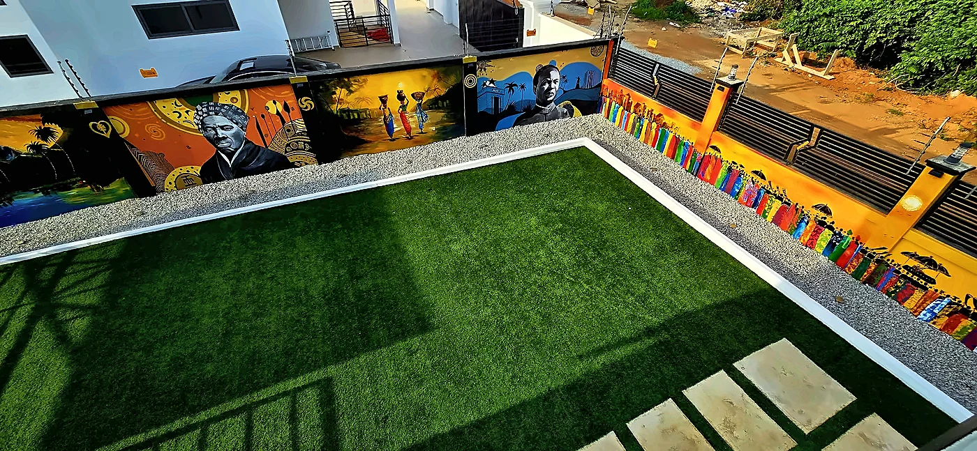 Rooftop terrace with artificial turf and a long painted mural wall